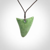 This is a lovely New Zealand Jade, pounamu niho drop pendant. Hand carved for us by Ric Moor. It is bound with an adjustable brown coloured cord which is length adjustable. Free worldwide shipping.